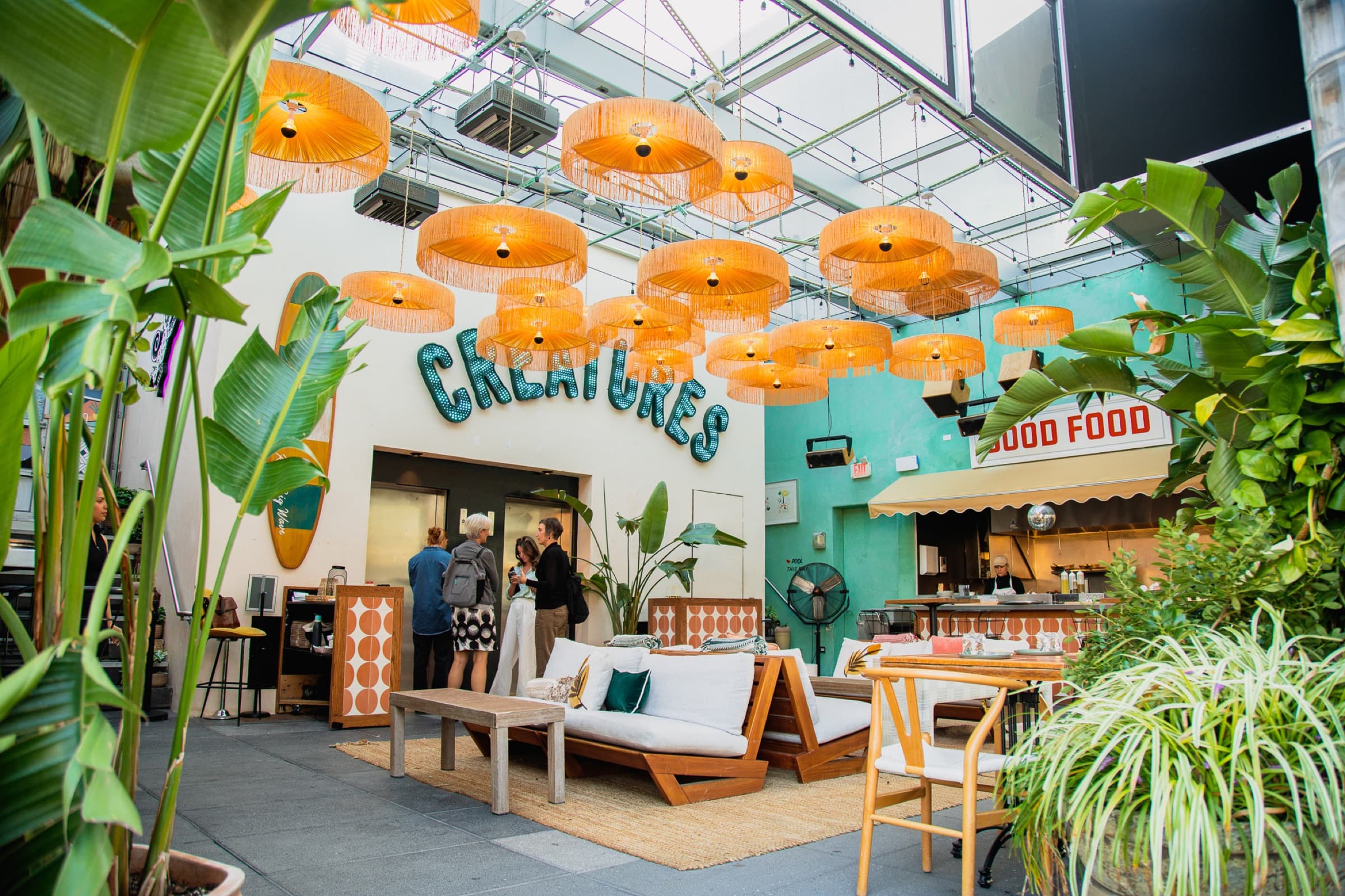 The rooftop room at Creatures under orange rattan pendants, with the Good Food counter to one side